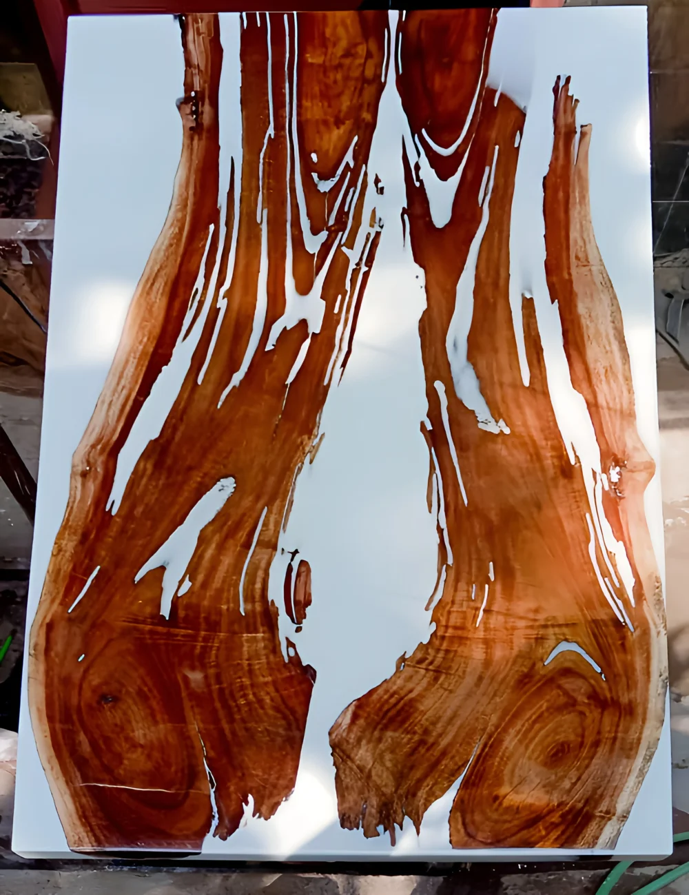 A unique coffee table crafted from a slab of polished wood with resin, showcasing intricate wood grain patterns and a white resin inlay.