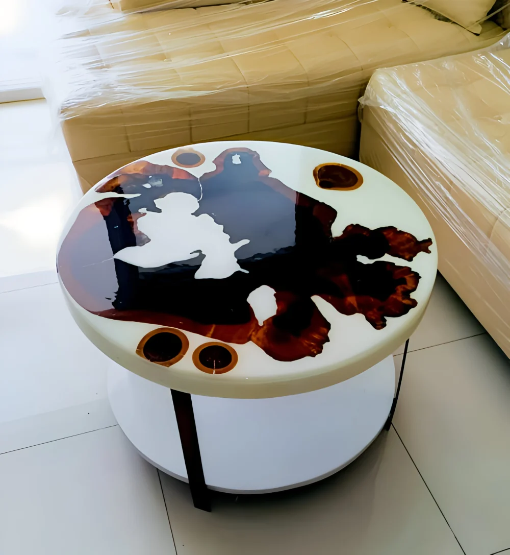 A round side table with a unique resin top featuring a dark brown and white abstract design.